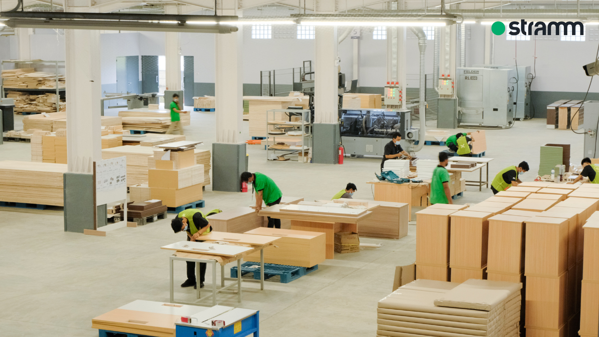 Pabrik furniture STRAMM dengan aktivitas pekerja memproduksi dan merakit berbagai komponen furniture dari material kayu.
